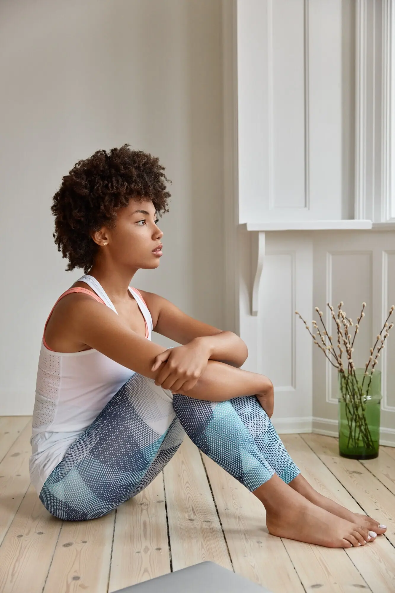 Задумчивая милая женщина позирует у себя дома.